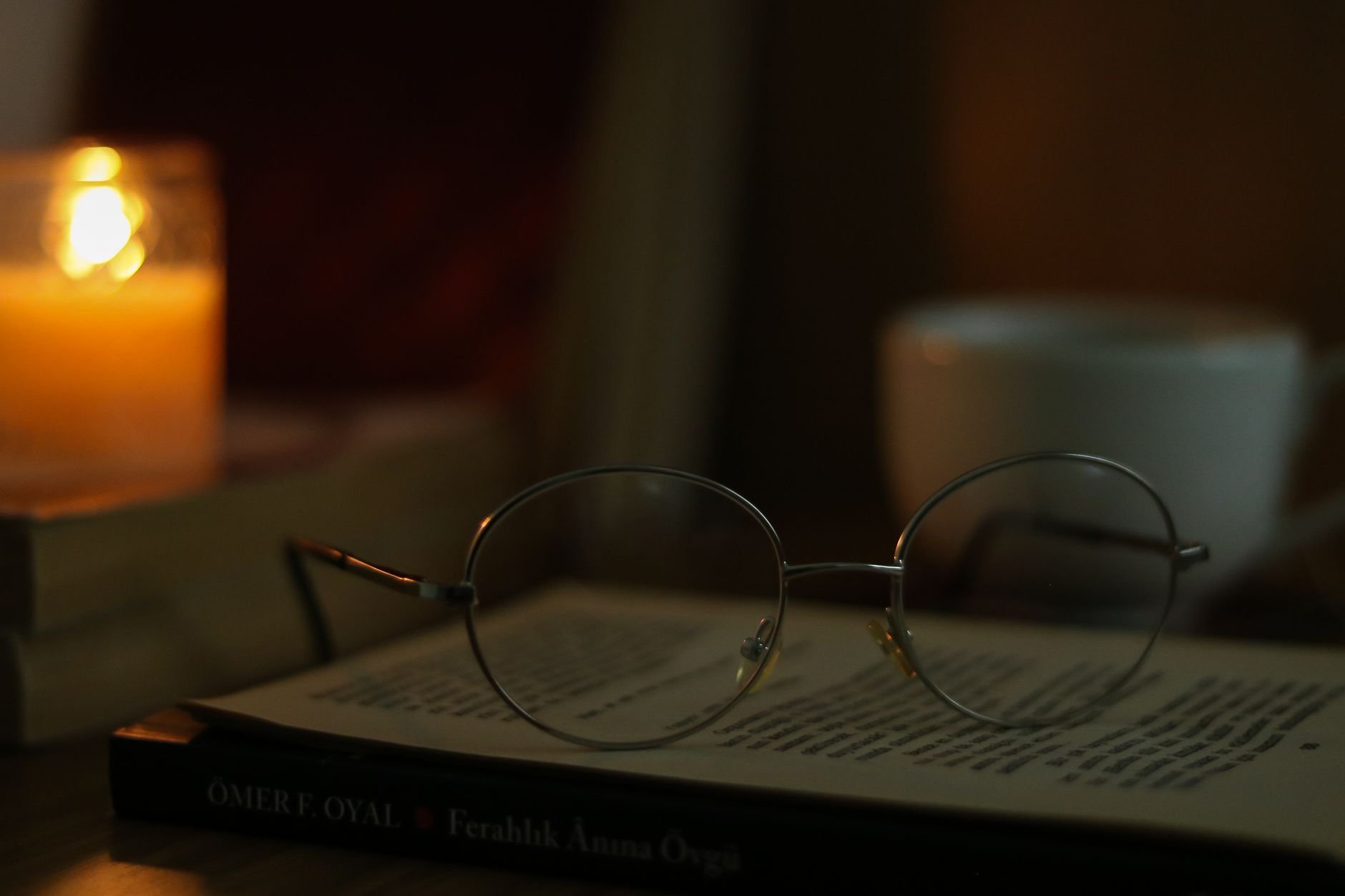 Warm candlelit café atmosphere with coffee and open book